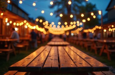 Fototapeta premium Outdoor beer garden set up at night. Long wooden tables with benches ready for visitors to sit, relax. String lights hang above, creating festive glow. People socialize, enjoying warm evening