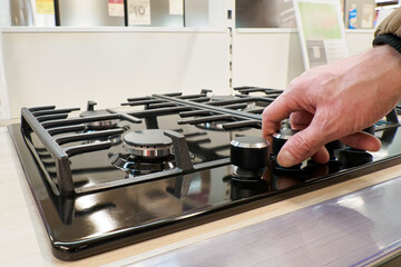 Gas stove. Turning on and off the gas burner. A home appliance store. Consumer