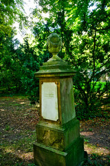 sehr alter Grabstein mit einer Urne auf einem Friedhof in Ulm