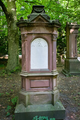 großer alter roter Grabstein mit weißer Platte auf einem Friedhof in Ulm © Blende8