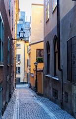 Fototapeta premium Narrow cobblestone alley in a historic city with an antique lantern