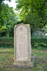 sehr alter Grabstein, schöne Steinmetzarbeit auf einem Friedhof in Ulm © Blende8