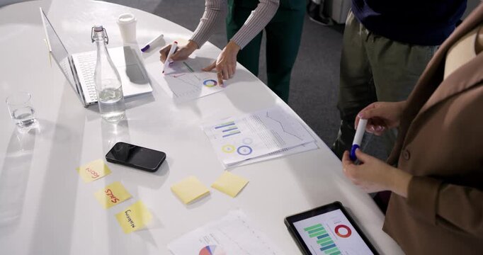 Diverse colleagues using charts annotating data and planning with peer joining at conference table