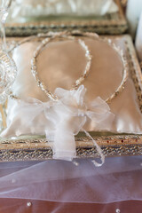 Two silver wedding rings on a decorative cushion in a setting for a wedding ceremony