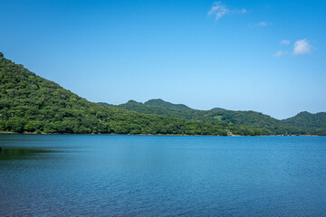 Obraz premium 群馬県大沼の青空と湖、夏の雄大な水面と山並みの風景