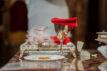 Table set with silver cup and red napkin during a ceremonial event in a grand hall