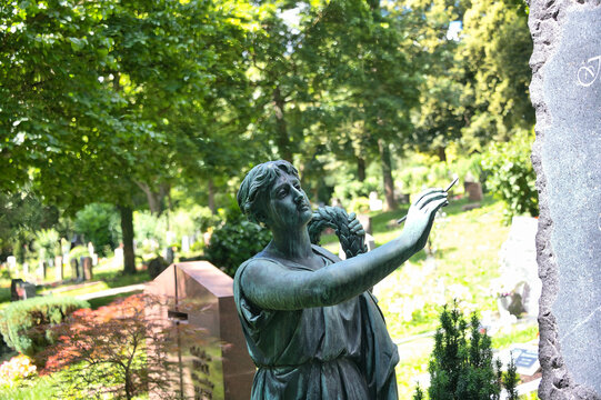 Ein Grabstein wird beschriftet, sch&ouml;ne Statue mit einer Schreibfeder auf einem Friedhof in Ulm