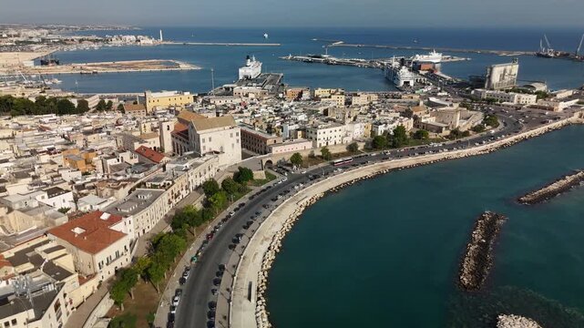 Aerial panoramic view of Bari, Italy on the Adriatic Sea coast with marina, yachts, lighthouse, waterfront promenade, historic architecture and modern cityscape under summer sunlight