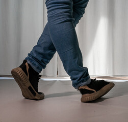 Young guy in a dancing pose on a white background. Modern dance in a plaid shirt. Sports plastic...