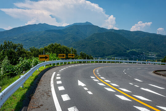 群馬県渋川市の夏の山岳道路、カーブと矢印の先の未来