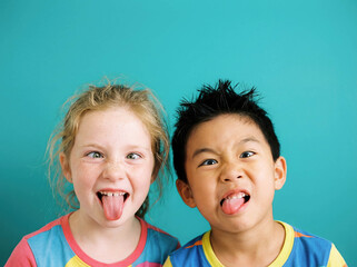 Obraz premium Funny diverse kids making faces copy space grimace playful humor multiethnic children sticking tongue out happy friends crazy mood caucasian asian african studio background emotion childhood prank