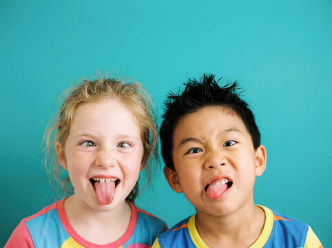 Funny diverse kids making faces copy space grimace playful humor multiethnic children sticking tongue out happy friends crazy mood caucasian asian african studio background emotion childhood prank