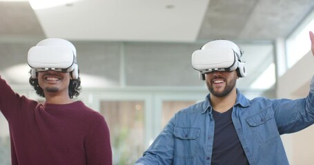 Upon launching VR demo, male coworkers wearing headsets raising arms testing interface at lab