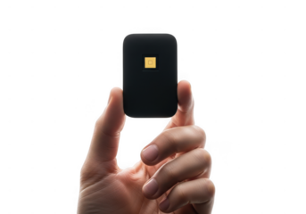 A hand holding a small black electronic device with a gold square detail isolated on transparent background