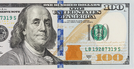 A picture of a part of a100 bill. It's the American money