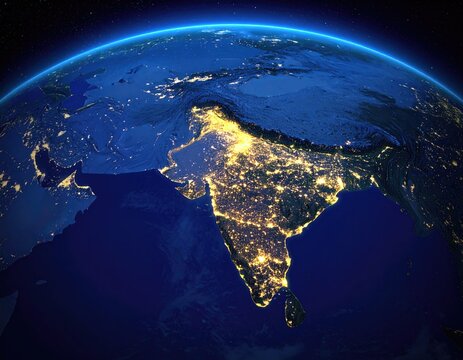 A night view of a glowing Indian subcontinent from space, with city lights and oceans