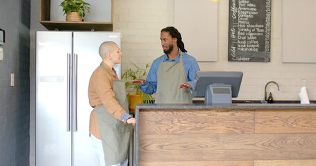 Diverse coworkers leaning and nodding after greeting, discussing day's specials at cafe counter