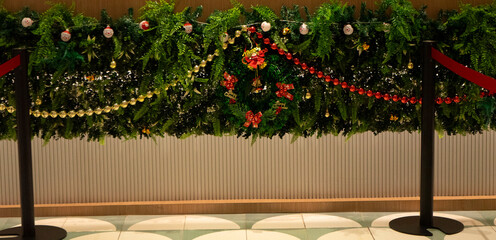 A beautifully decorated Christmas tree stands in the center of an elegant hotel lobby, surrounded...