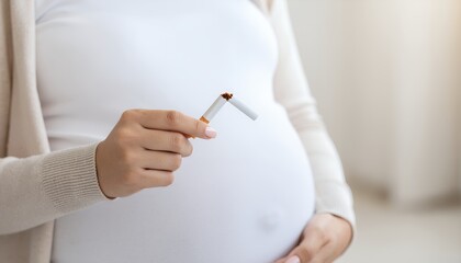 Pregnant woman breaking a cigarette symbolizing quitting smoking