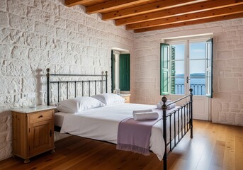 Obraz premium Mediterranean bedroom interior with stone walls and open balcony door overlooking blue sea