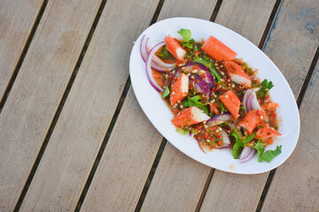 Spicy Thai salad with crab sticks and red onion.