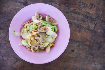 Stir-fried pork with Chinese cabbage and egg on a pink plate.