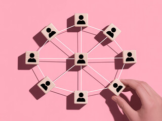 Build your network and connect with others using this social network concept with wood blocks on a pink background for your business