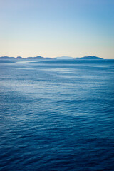 Beautiful calm Aegean Sea with islands of the Cyclades on the horizon.