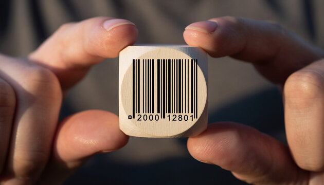 Close-up of a barcode on a wooden cube held between two fingers. - Powered by Adobe