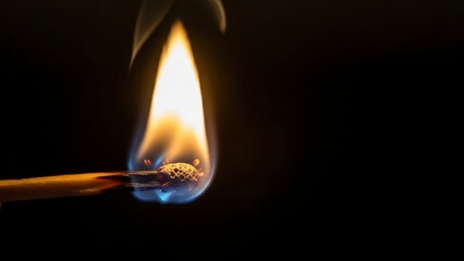 Close-up of a single wooden matchstick burning brightly in the dark, creating a warm and captivating glow.