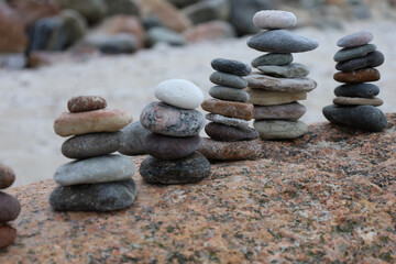 Calm beach sculpture, Peaceful cairns creating tranquil seaside meditation scene, Harmonious stone arrangements on beach evoke relaxation and exploratory leisure activities