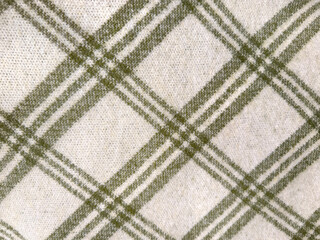 Close up of tartan pattern in diagonal arrangement, in green, grey, and white color. Tartan style is very common in scarf, shawl, winter shirts, and fashion industry. Seamless background texture.