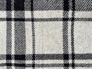 Close up of table cloth runner with black and white lines tartan pattern. Tartan style is very common in scarf, shirts, and fashion industry. Seamless background texture.