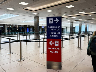 Naklejka premium Busy Dublin Airport terminal in Ireland with directional sign for EU UK citizens and non EU travelers