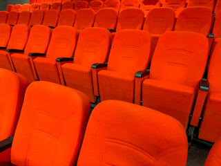 Obraz premium The rhythmic arrangement of the red fabric event hall chairs in their empty state.