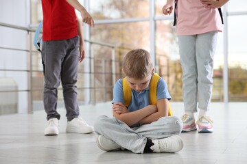 Boy getting bullied by his classmates in school, closeup