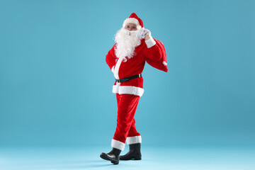 Santa Claus with bag on light blue background. Merry Christmas and Happy New Year