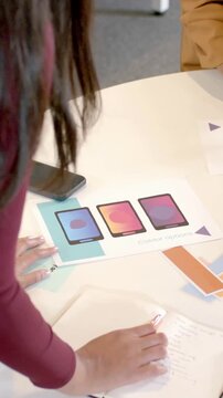 Vertical video: Two designers grabbing marker, comparing swatches in office for choosing palette