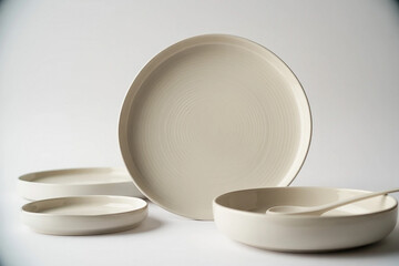 Minimalist ceramic dinnerware set with plates and bowls on a white background