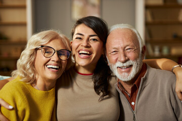Obraz premium Portrait of loving senior parents and their adult daughter at home