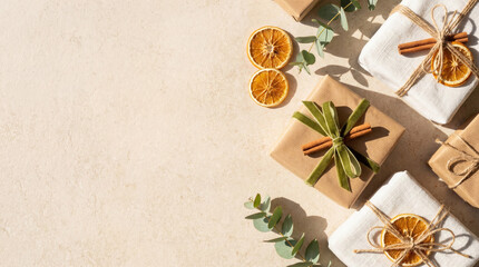 Flat lay of eco-friendly Christmas gifts wrapped in kraft paper and fabric, decorated with dried oranges, cinnamon sticks, and eucalyptus.