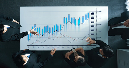 Business professionals analyze financial growth and data charts during a collaborative meeting in a modern office, highlighting teamwork and strategy. Scalp