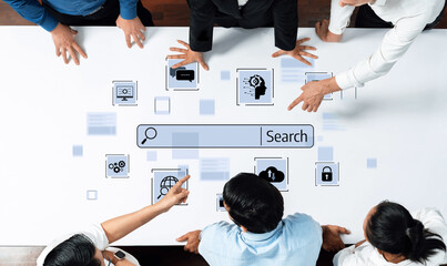 A diverse team collaborates around a table, engaging with a digital search interface and various icons that symbolize technology, communication, and innovation. Trope