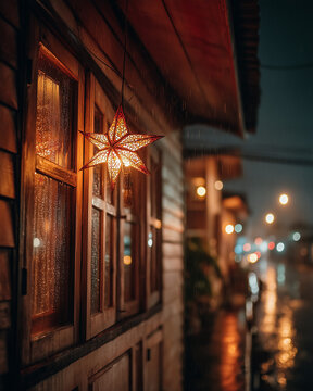 Star-shaped Filipino parol lantern glowing outside a rainy wooden window on a quiet Christmas village night