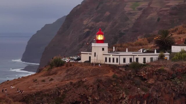 Ponta do pargo lighthouse shines brightly overlooking the atlantic ocean during dusk in beautiful madeira portugal