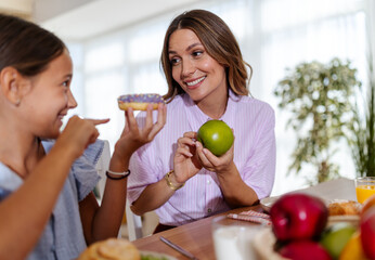 Mother and daughter share breakfast snacks