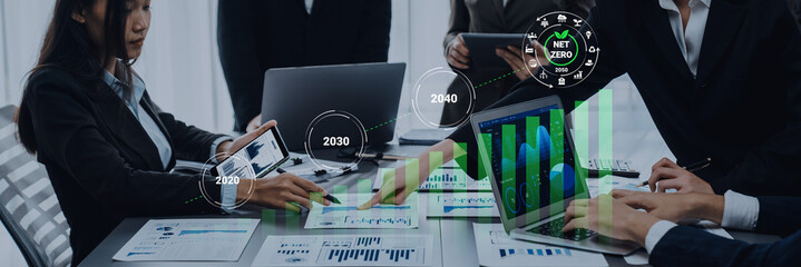 A dynamic business meeting focused on data analysis and sustainability goals. Professionals discuss strategies using modern devices, showcasing visual charts and growth metrics. Gantry