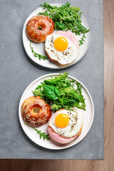 Healthy breakfast. Bagel sandwich with fried egg, ham and greens