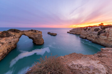 Albandeira Arch near Albandeira Beach. Cliffs and Atlantic Ocean in Evening Twilight. Algarve, Portugal