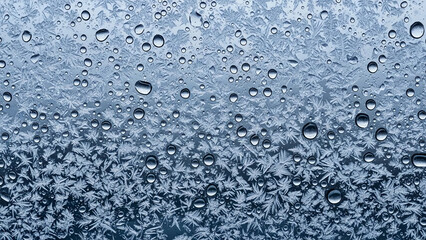 Obraz premium Close up of raindrops on a frosted glass surface with a blurred background